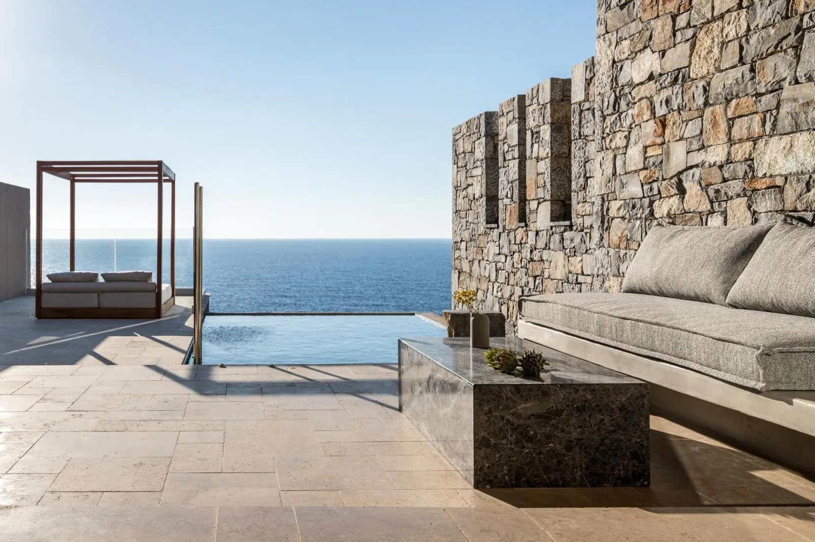 Suite terrace with private pool and daybed facing the sea at Acro Suites