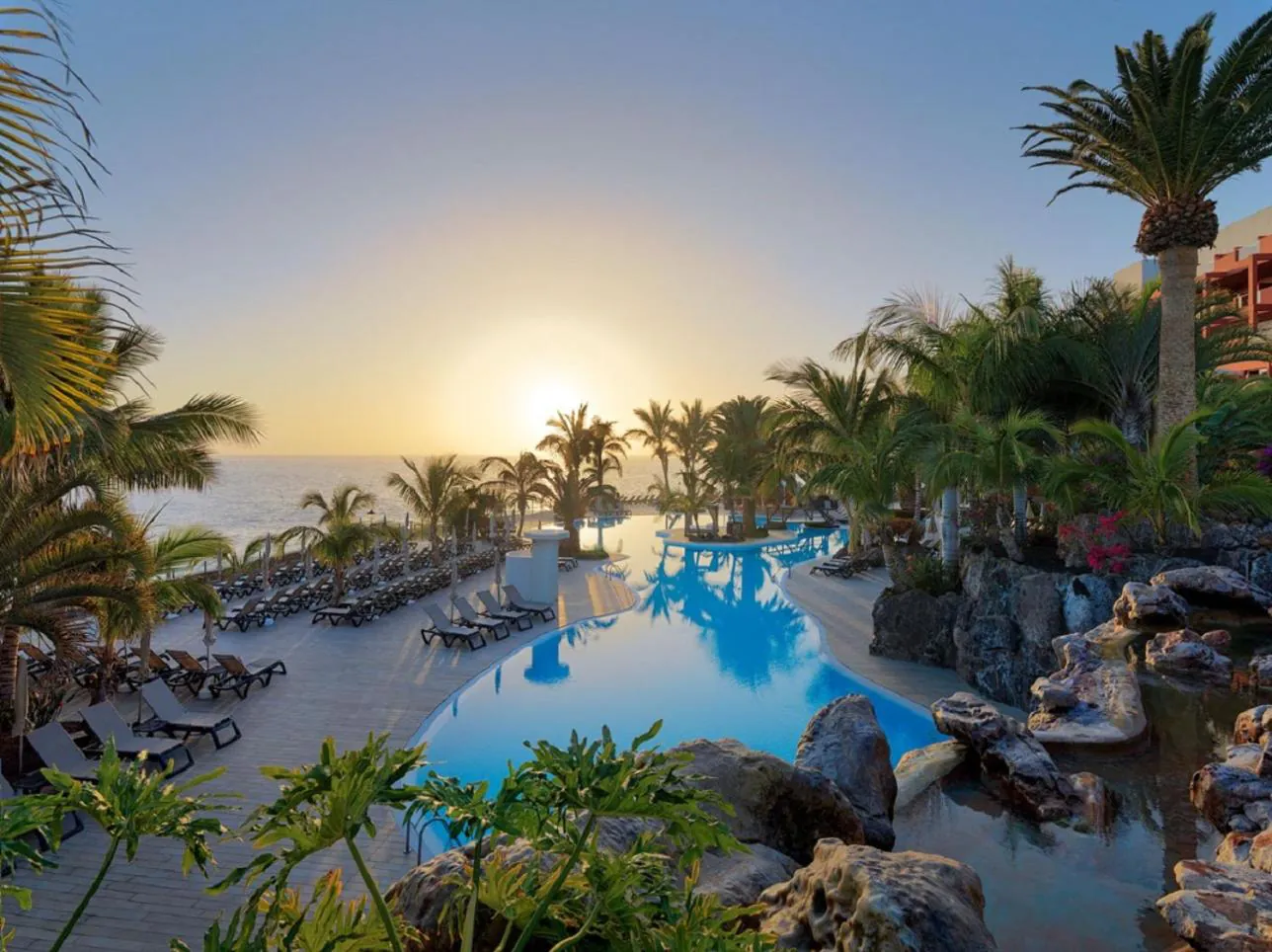 Sunset over the pool landscape and palms