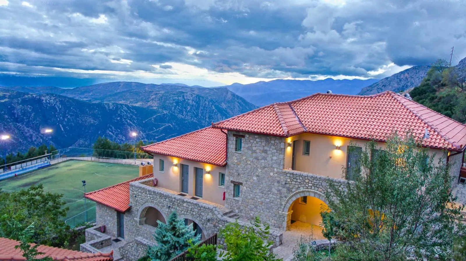 Stone hotel buildings above a valley with mountains behind