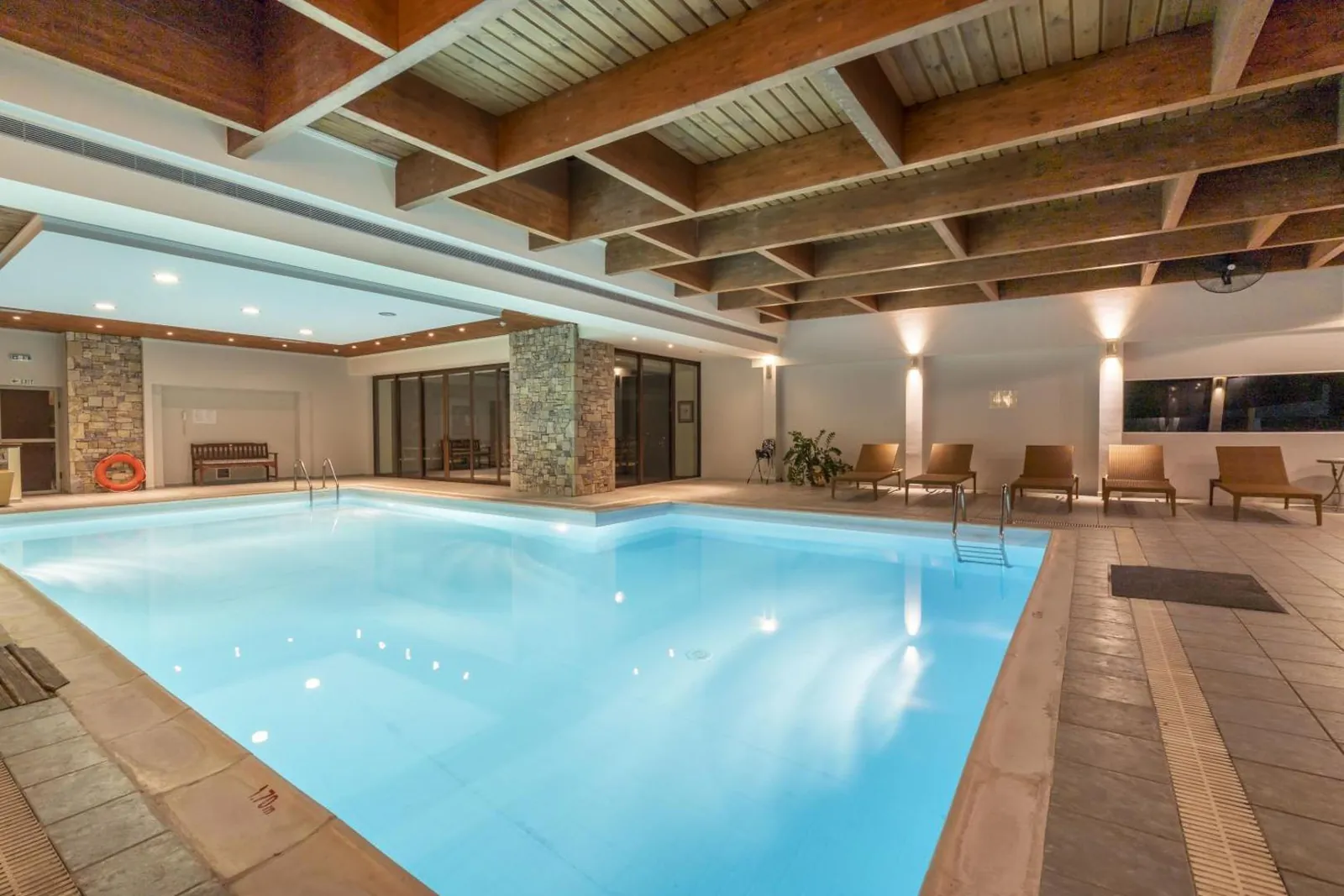 Indoor pool with a stepped edge and stone-clad pillars