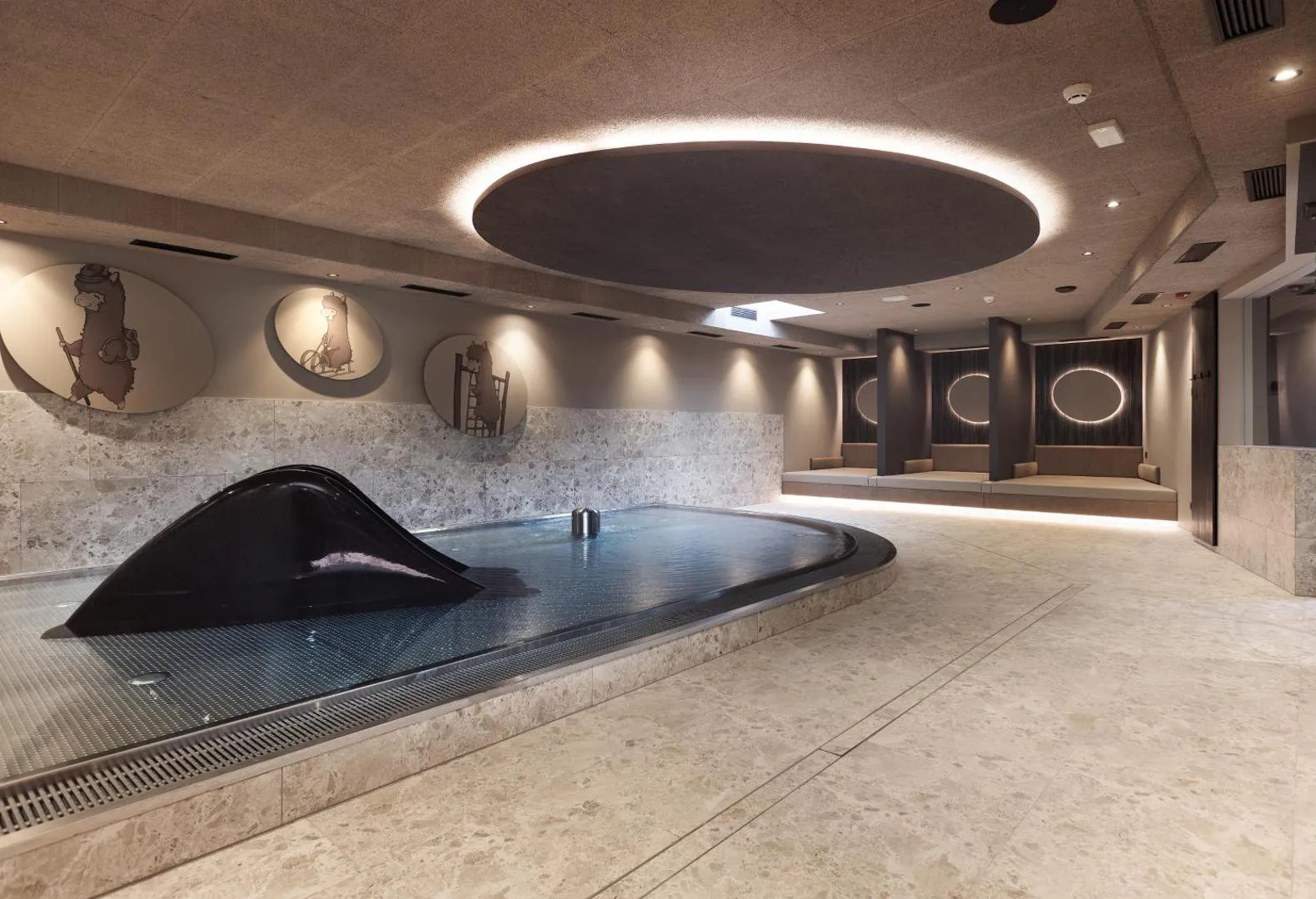 Indoor pool curving past a dark sculpture, with lounge beds alongside