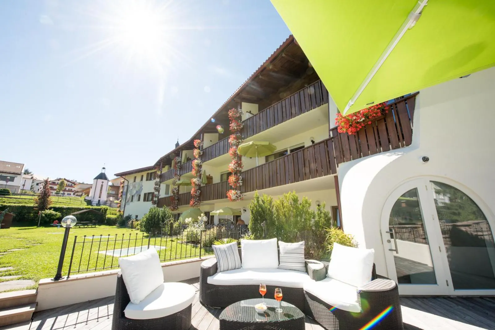 Apartment building with wooden balconies above the garden lounge