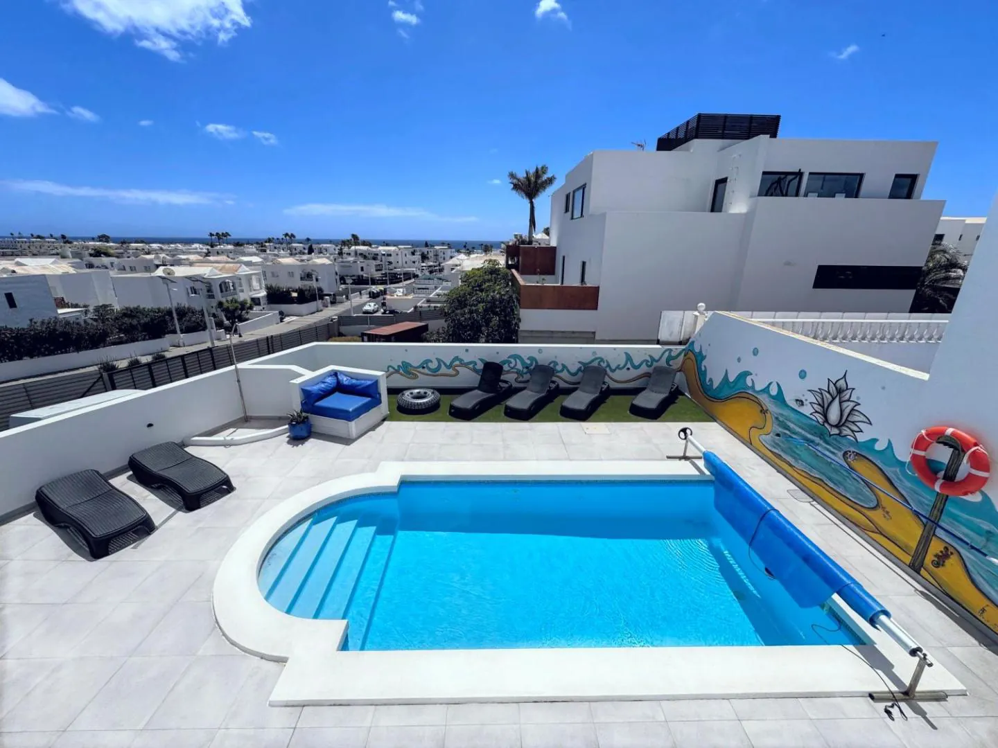Private pool with rounded steps on the terrace at Casa Vedas, with Puerto del Carmen and the sea behind