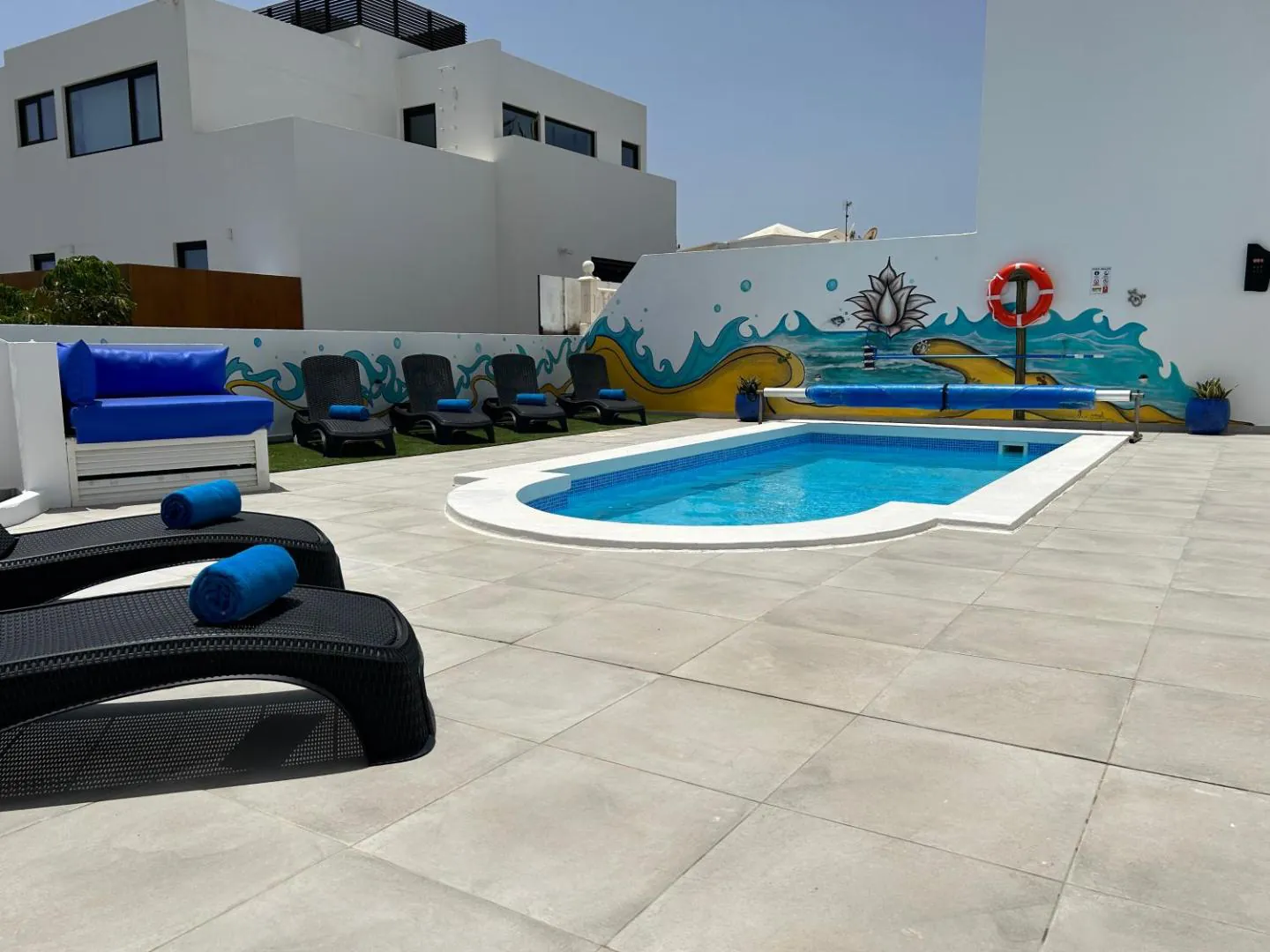 Pool terrace with loungers and a painted mural along the wall