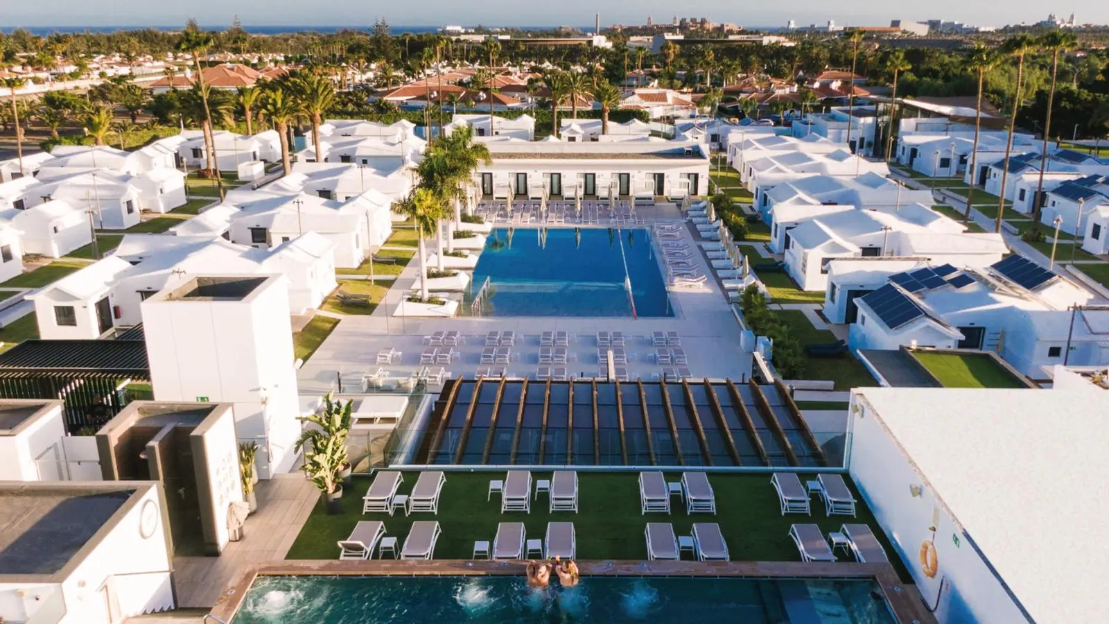 Aerial view of the pool and the white bungalow complex in Campo Internacional