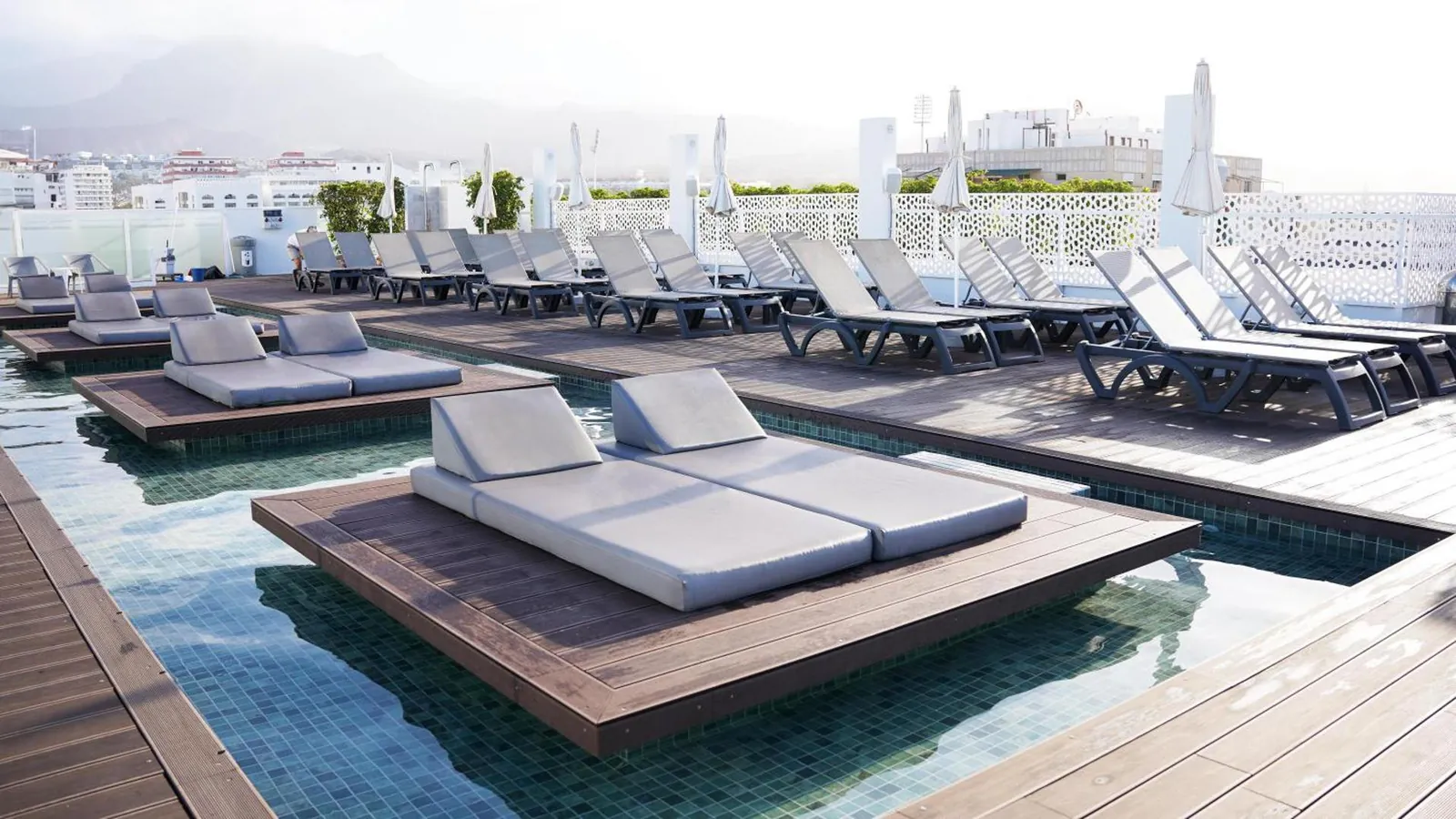 Rooftop deck with daybeds and loungers in shallow water