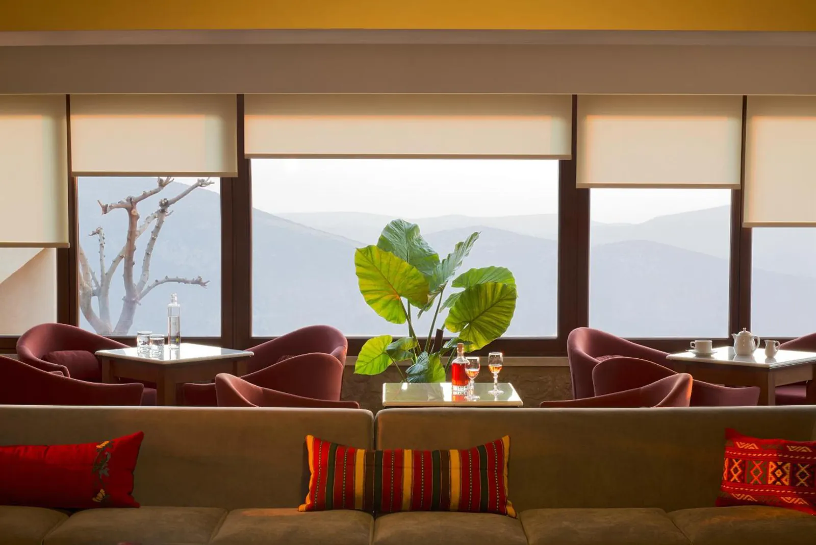 Lounge bar with armchairs facing windows over the mountains