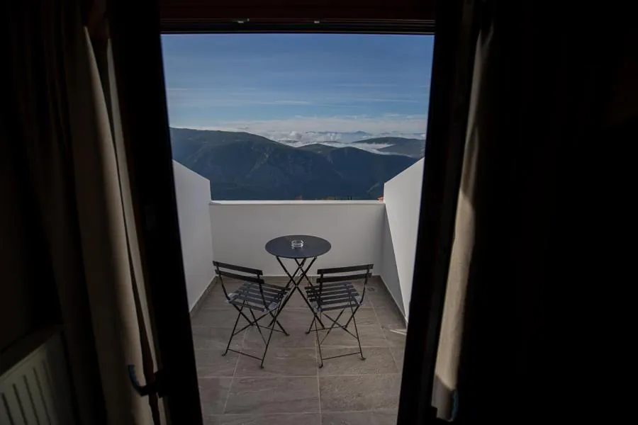 Balcony with a small table and chairs looking across Parnassos ridges