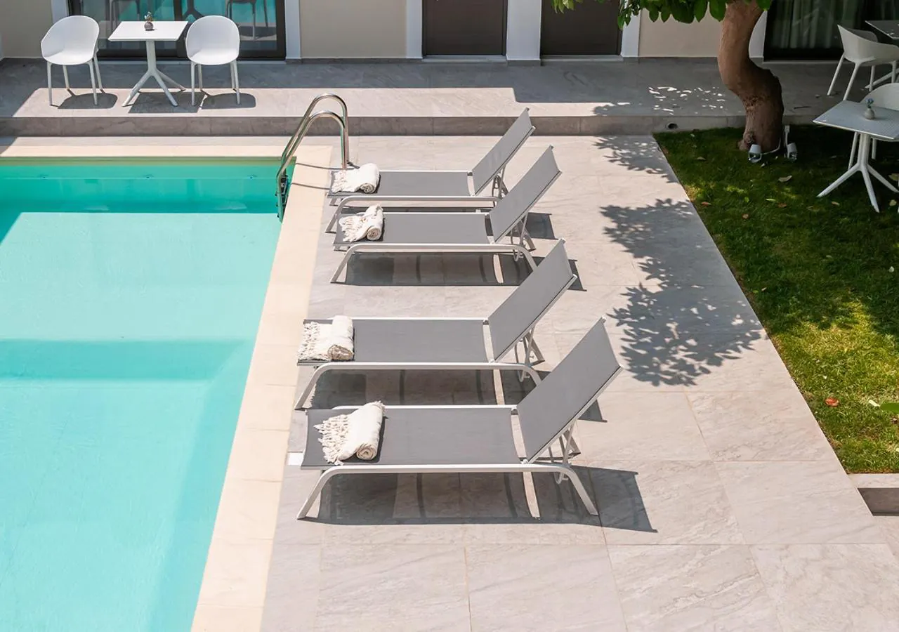 Long outdoor pool lined with grey sun loungers