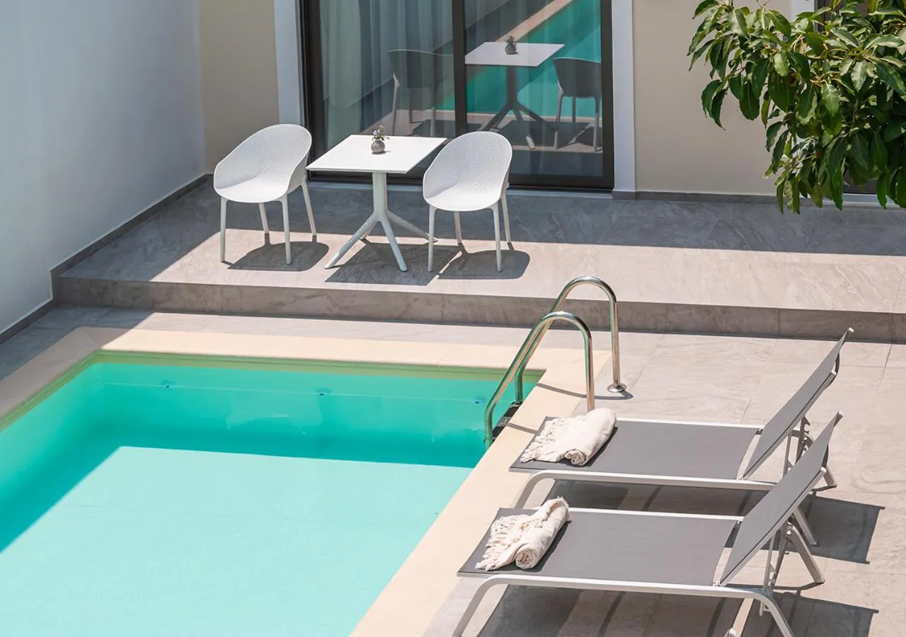 Suite terrace with a table and chairs stepping down to the pool