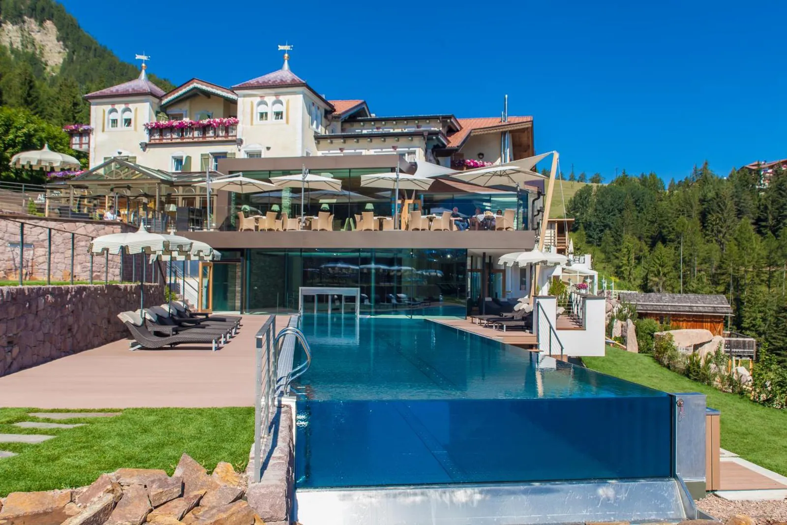 Hotel Albion above its glass-edged infinity pool and lawn in summer
