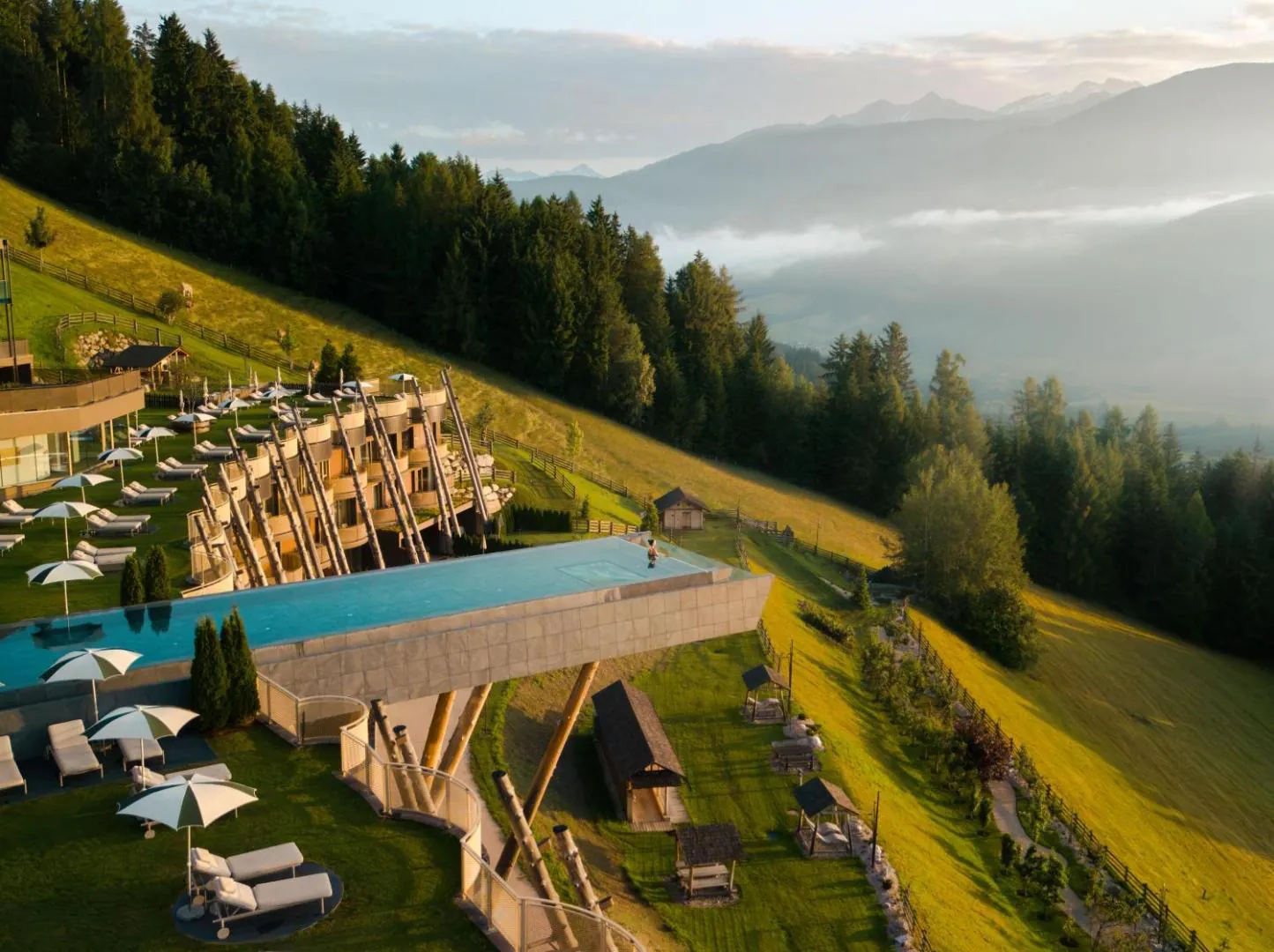 The cantilevered Sky Pool of Hotel Hubertus projecting from the hillside above Valdaora, seen from the air