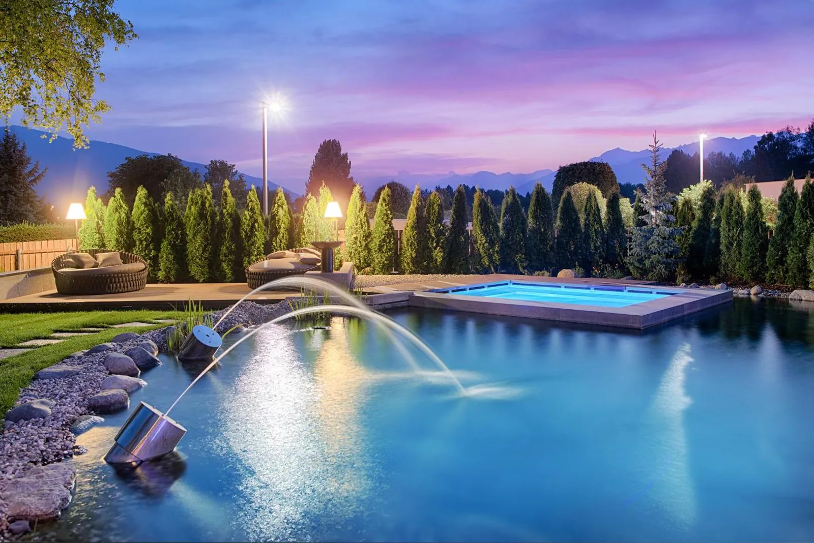 Garden pool with water jets at dusk