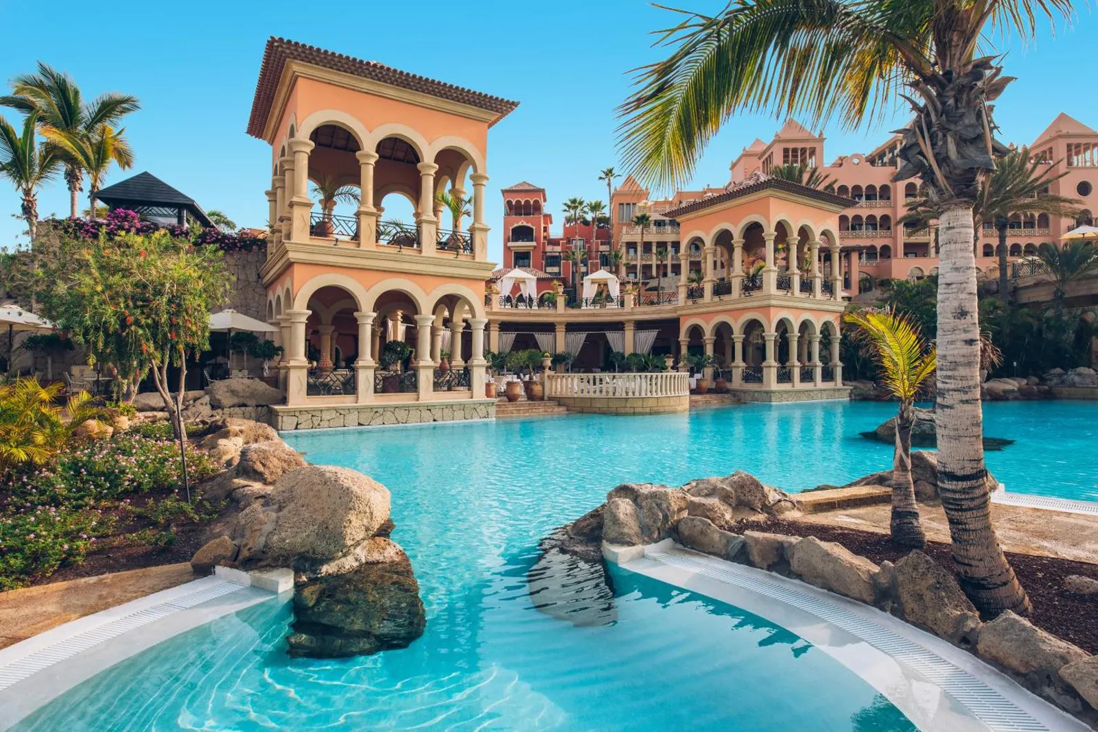 Pool terrace with palms and the colonial-style arches of JOIA El Mirador, Costa Adeje