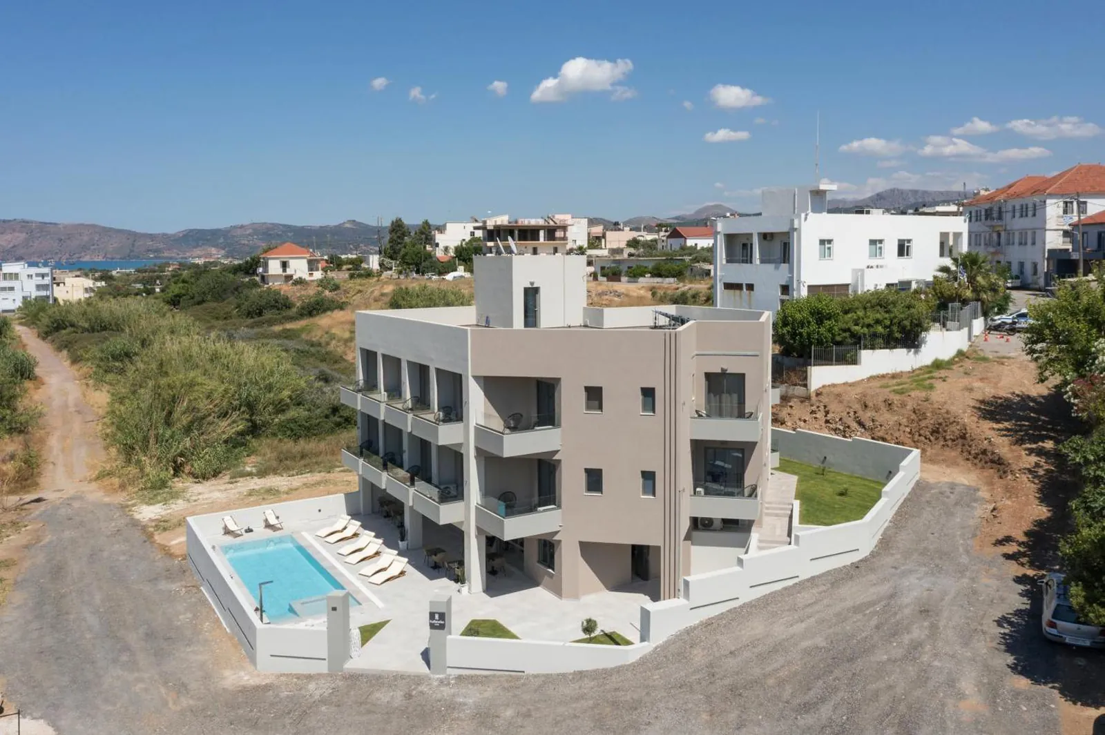 Aerial view of the hotel building and pool on the edge of Kissamos
