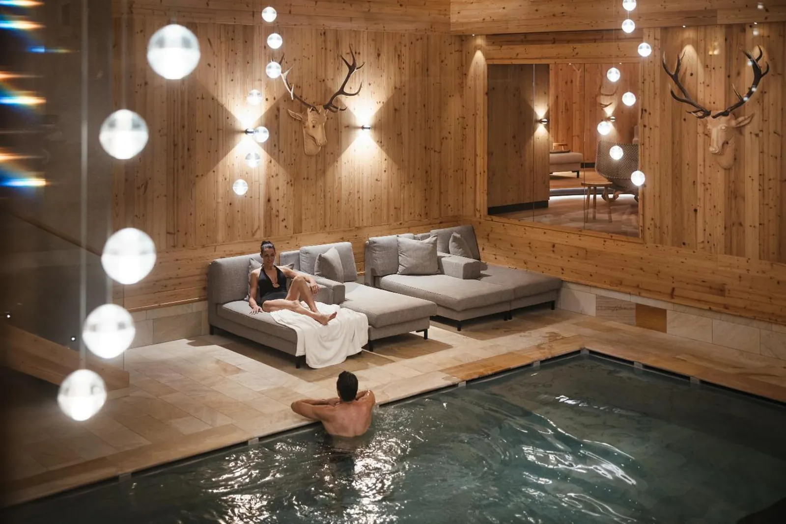 Indoor pool with lounge seating and pendant lights