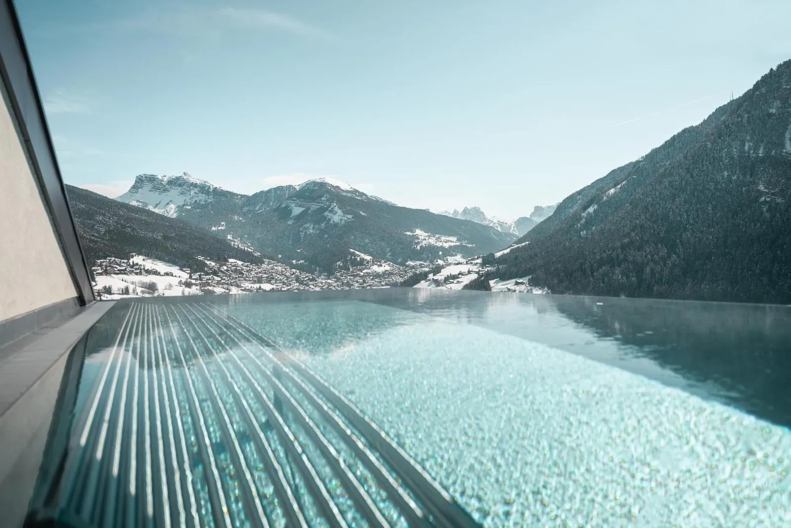 Infinity pool with a glass edge looking across the Val Gardena mountains at La Cort