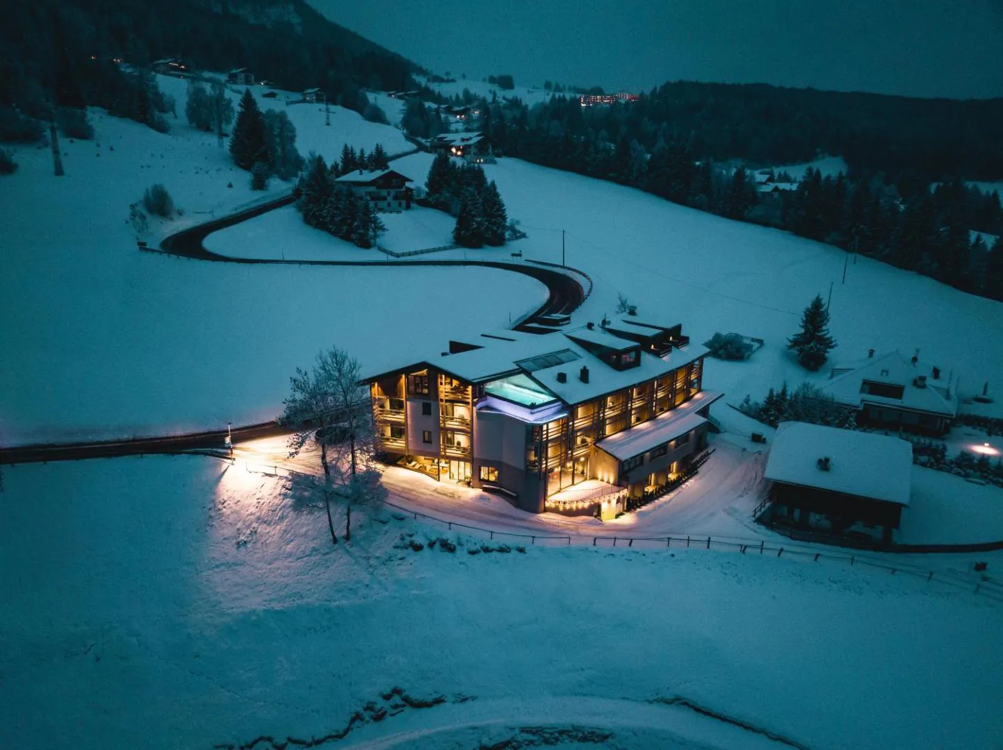 La Cort lit up at dusk in a snowy landscape