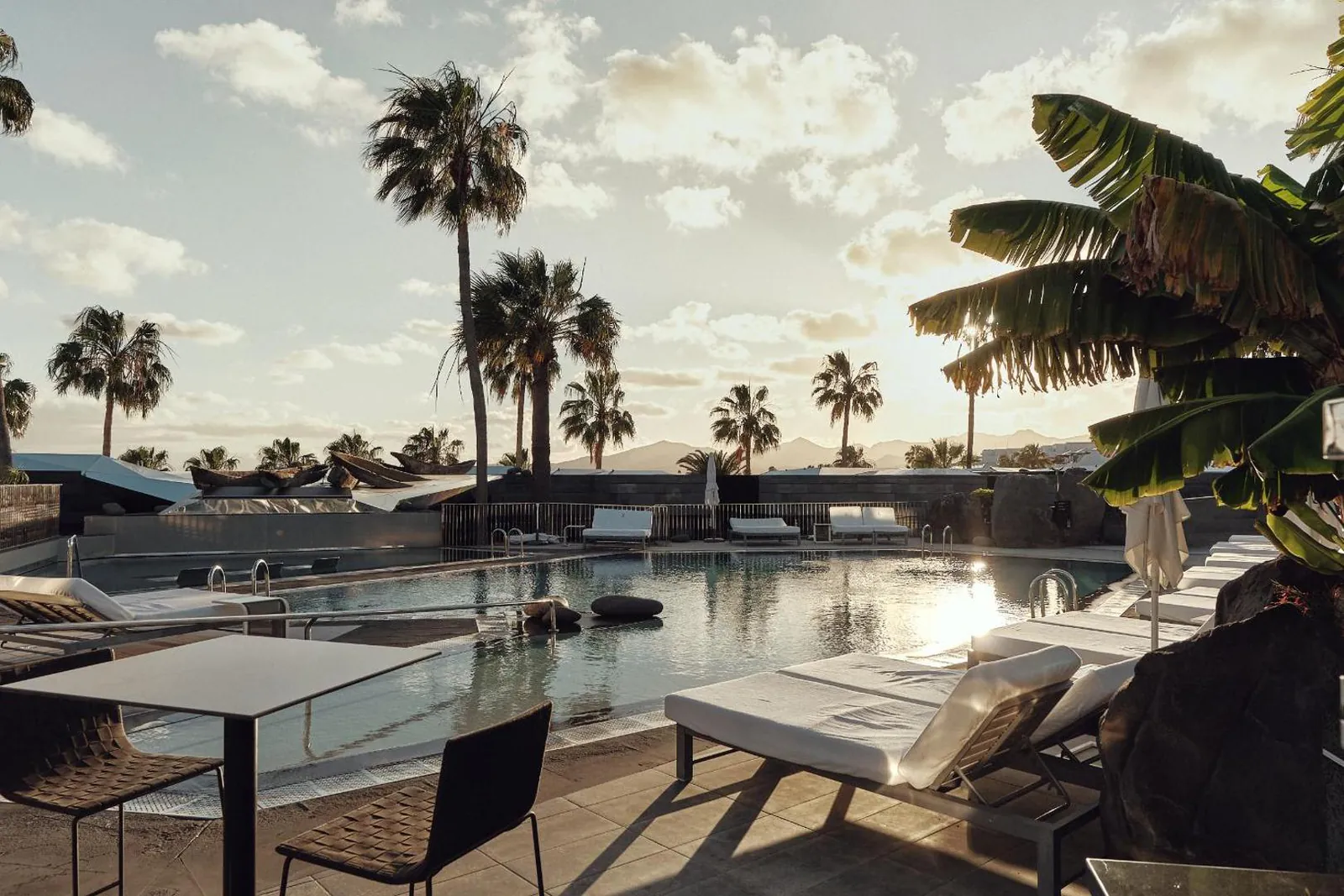 Poolside table and loungers with the sea on the horizon