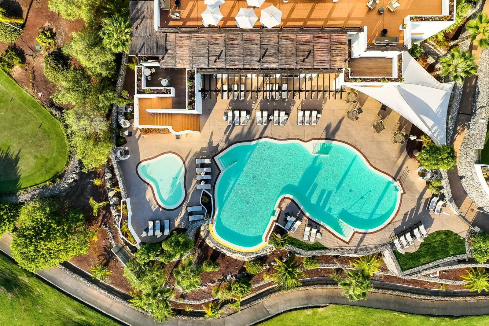 Aerial view of the linked pools and the kids' pool among gardens and terraces