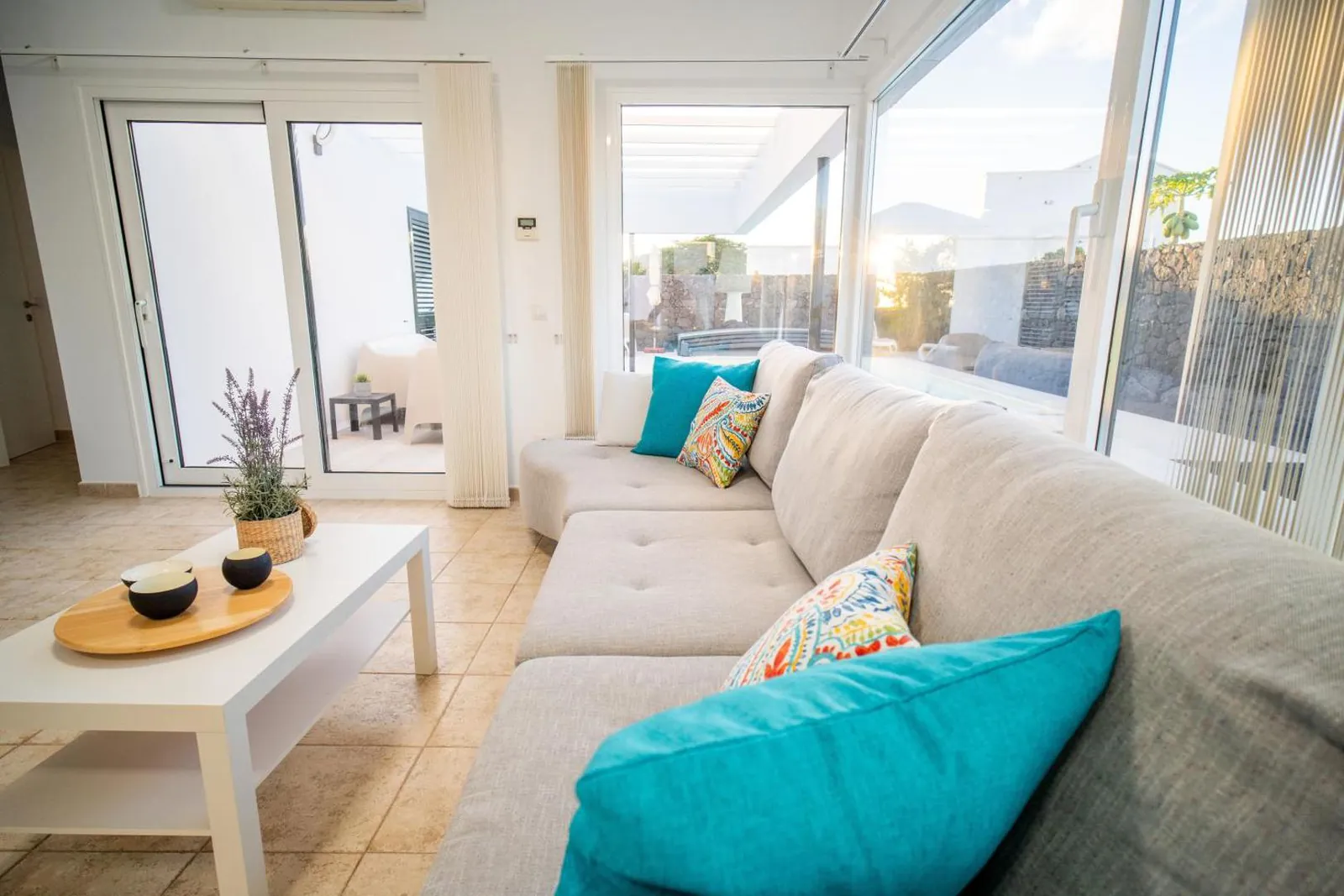 Living room with a large sofa and glass doors onto the terrace