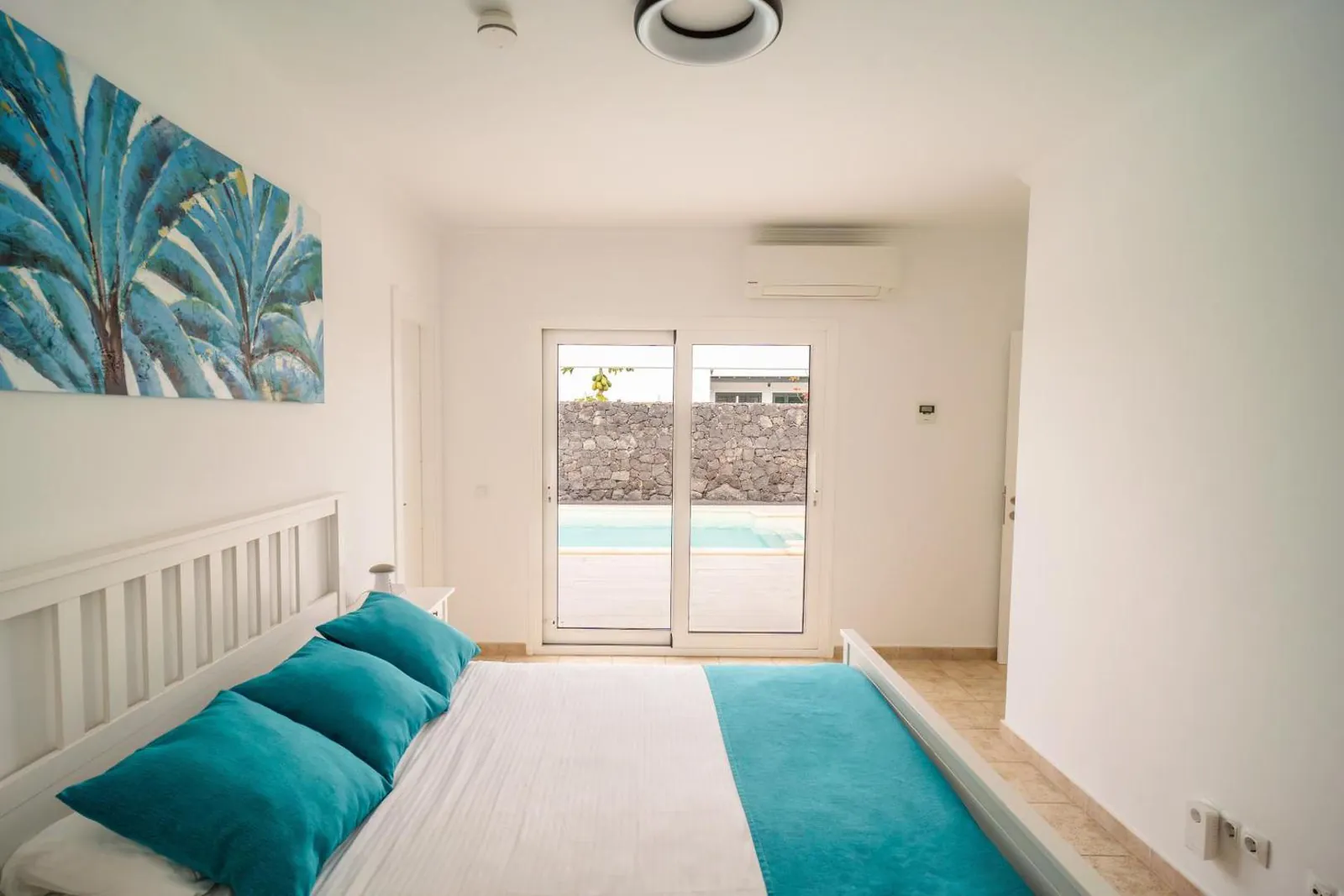 Bedroom with glass doors opening towards the pool