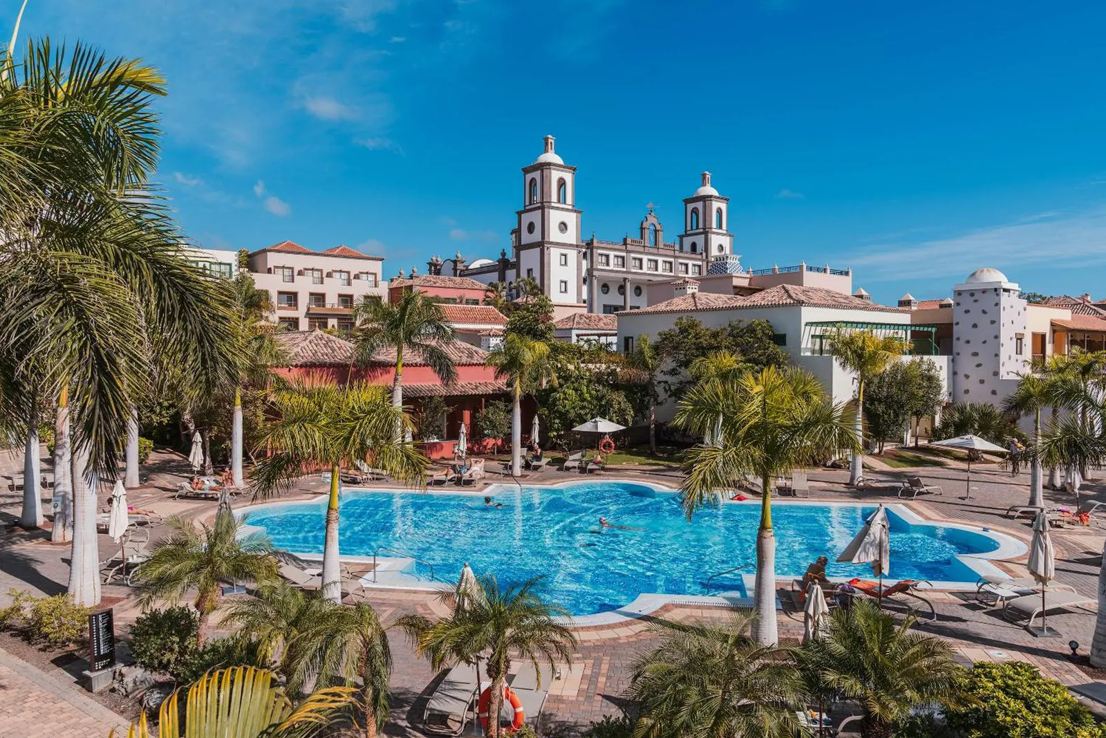 Main pool among palms with the resort's twin-towered church behind