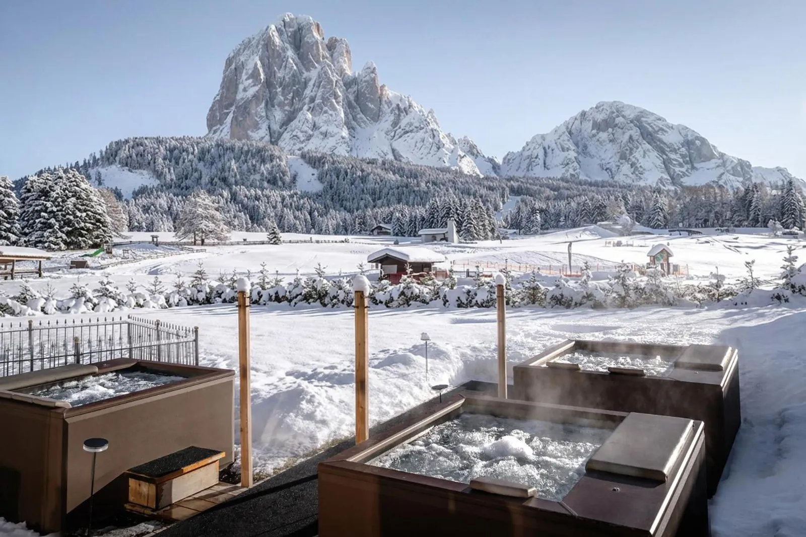 Outdoor whirlpool in the snow facing the Sassolungo at Monte Pana Dolomites Hotel
