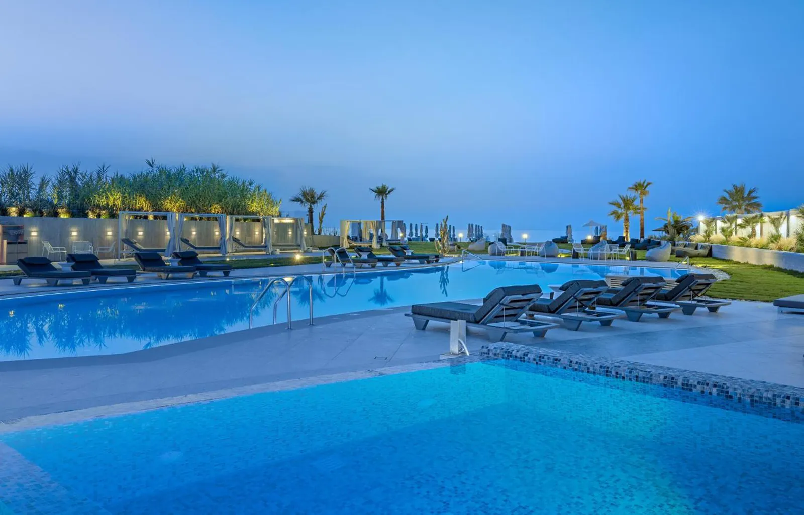Outdoor pool with loungers running towards the sea at Nautilux Rethymno