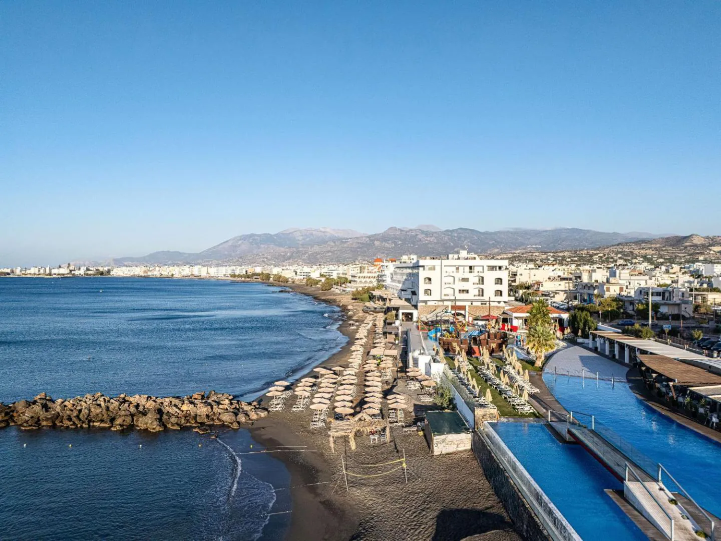 Aerial view of Petra Mare's pools and beach umbrellas on the Ierapetra seafront