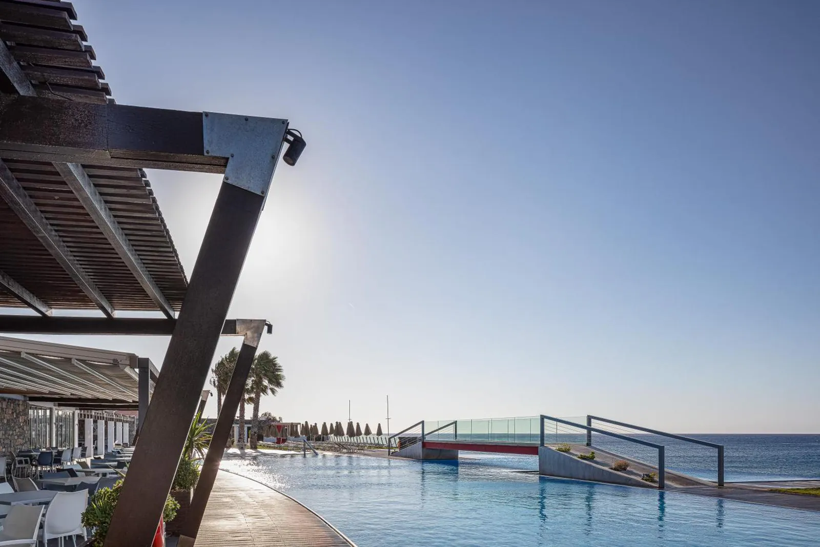 Pool edge facing the Libyan Sea under a shaded terrace