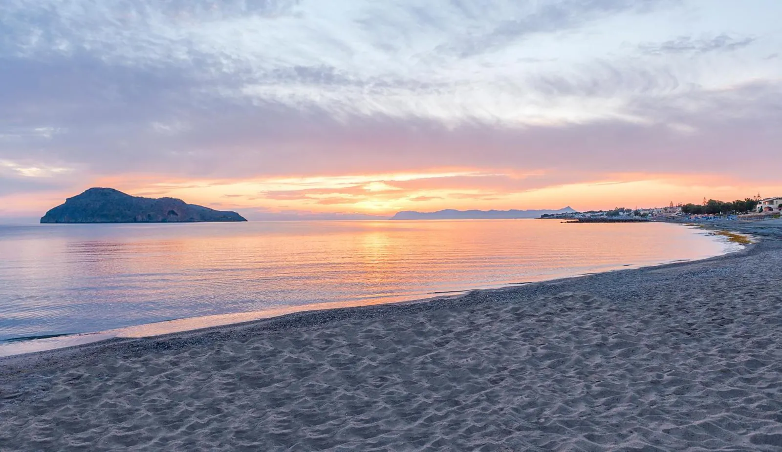 Sunset over the beach at Platanias with the island of Agii Theodori offshore