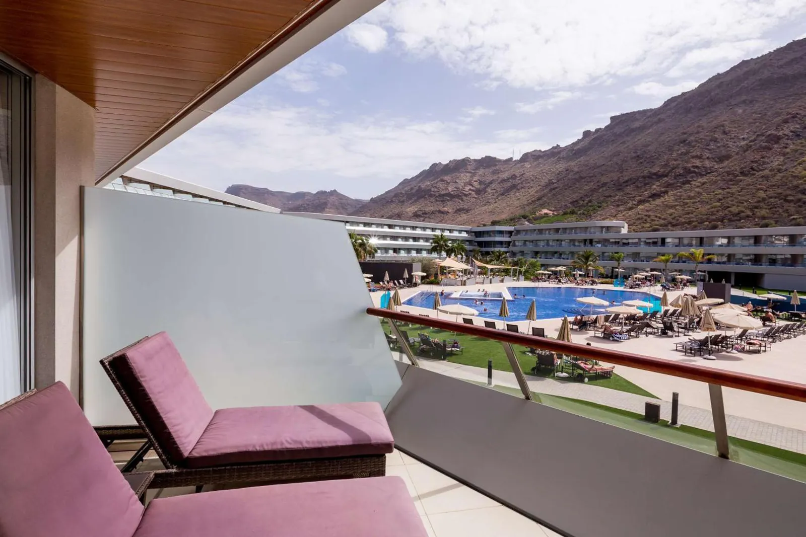 Balcony loungers looking down on the pools and up to the mountains