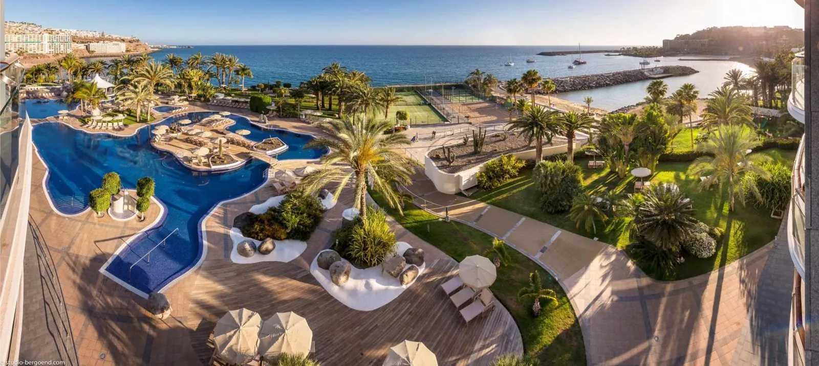 The pool garden from above, with the bay and coastline beyond