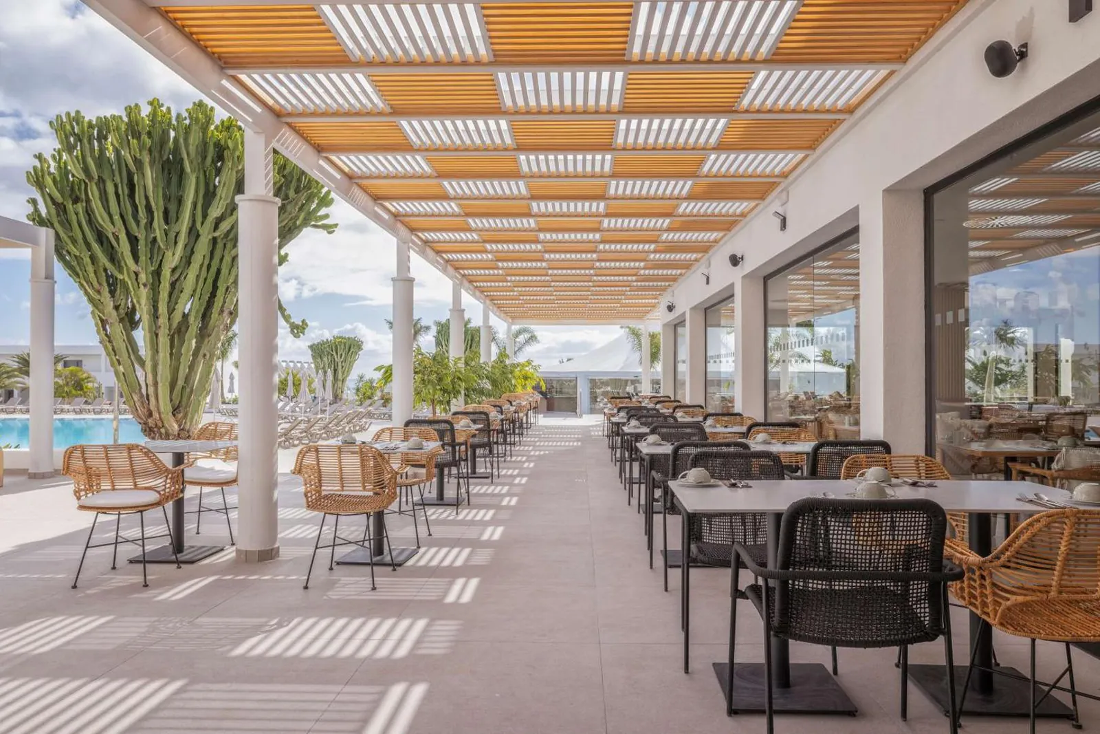 Covered outdoor restaurant terrace overlooking the pool