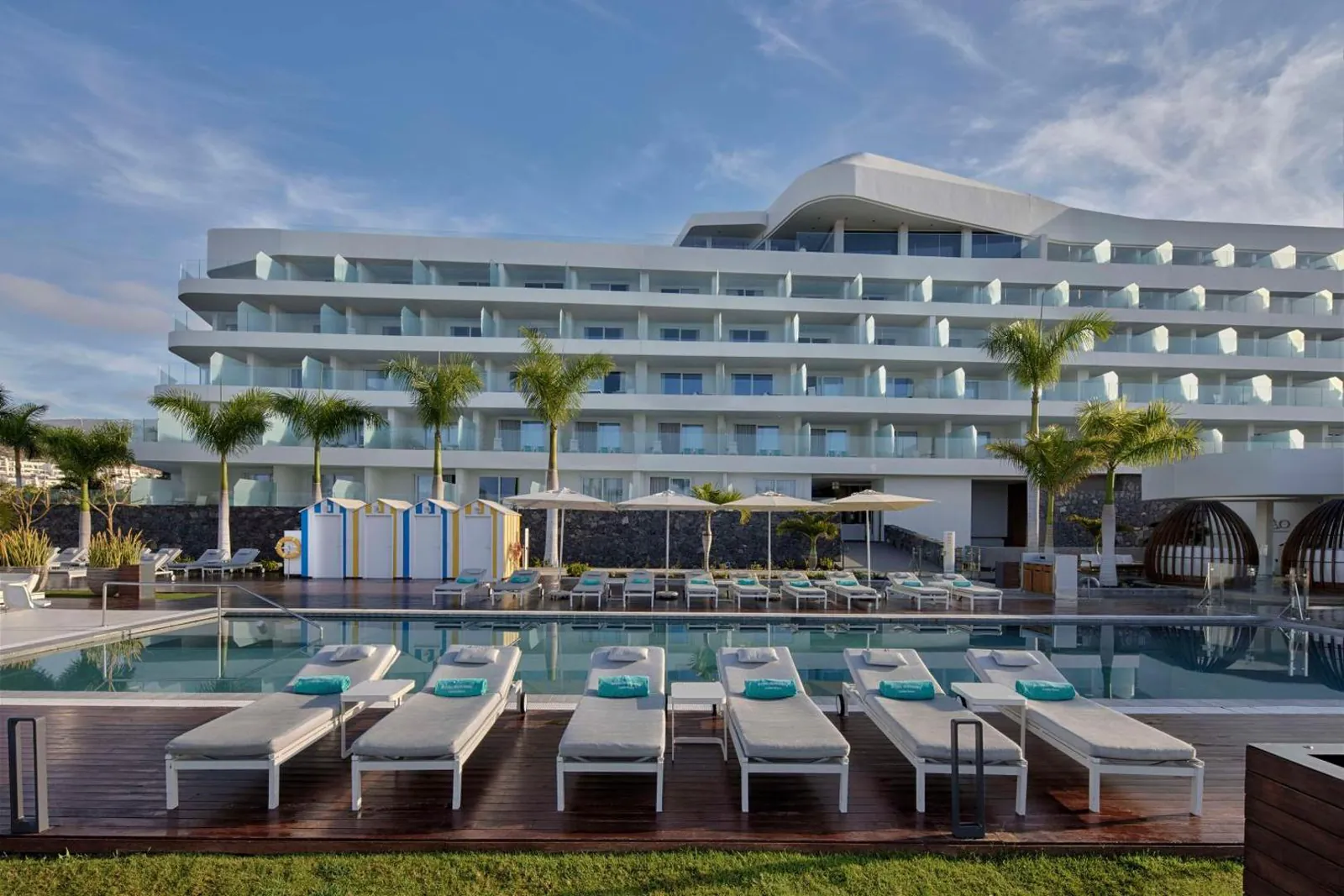 Pool with loungers in front of the terraced hotel facade