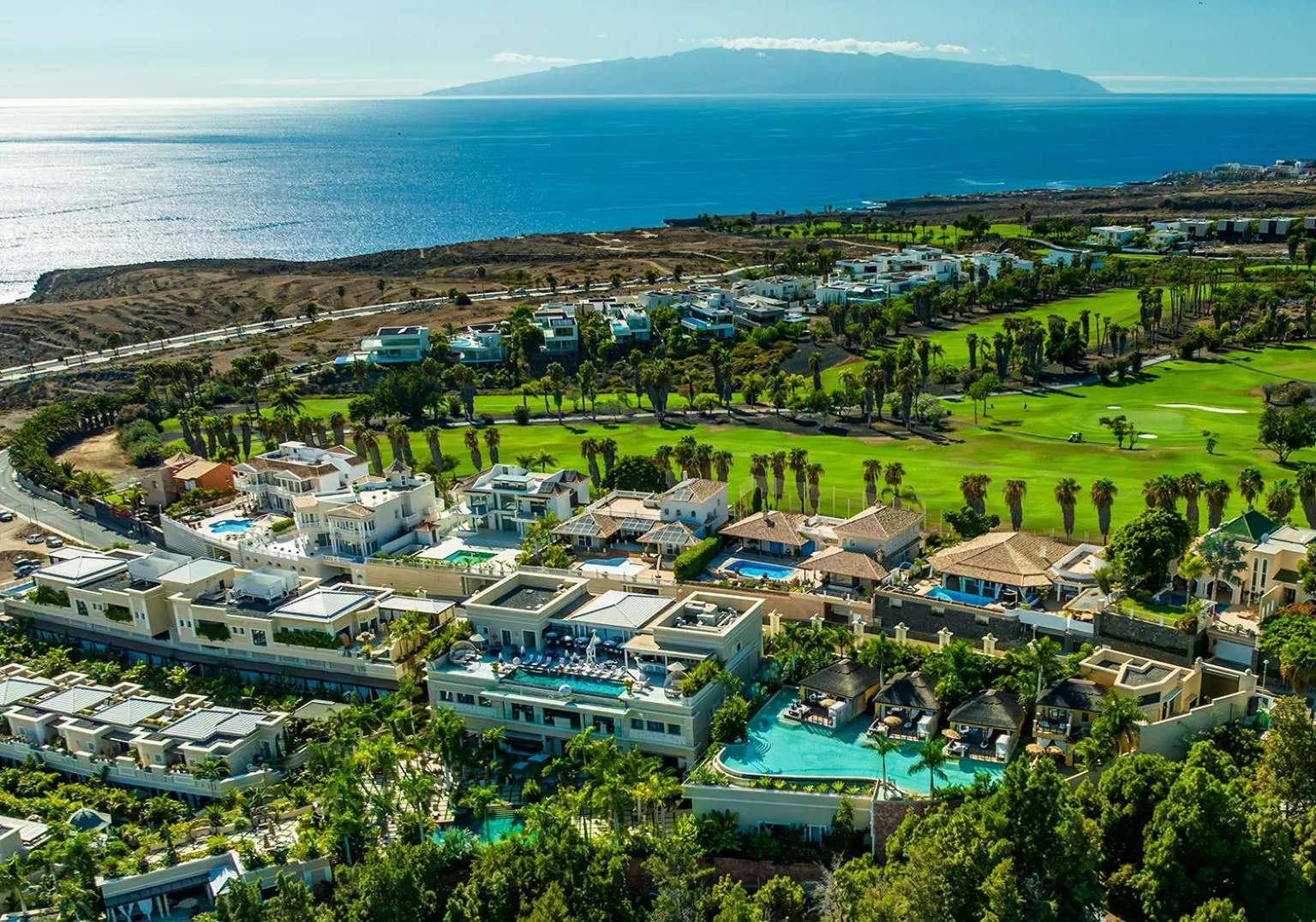 Aerial view of Royal River's villas beside the Costa Adeje golf course, sea in the distance