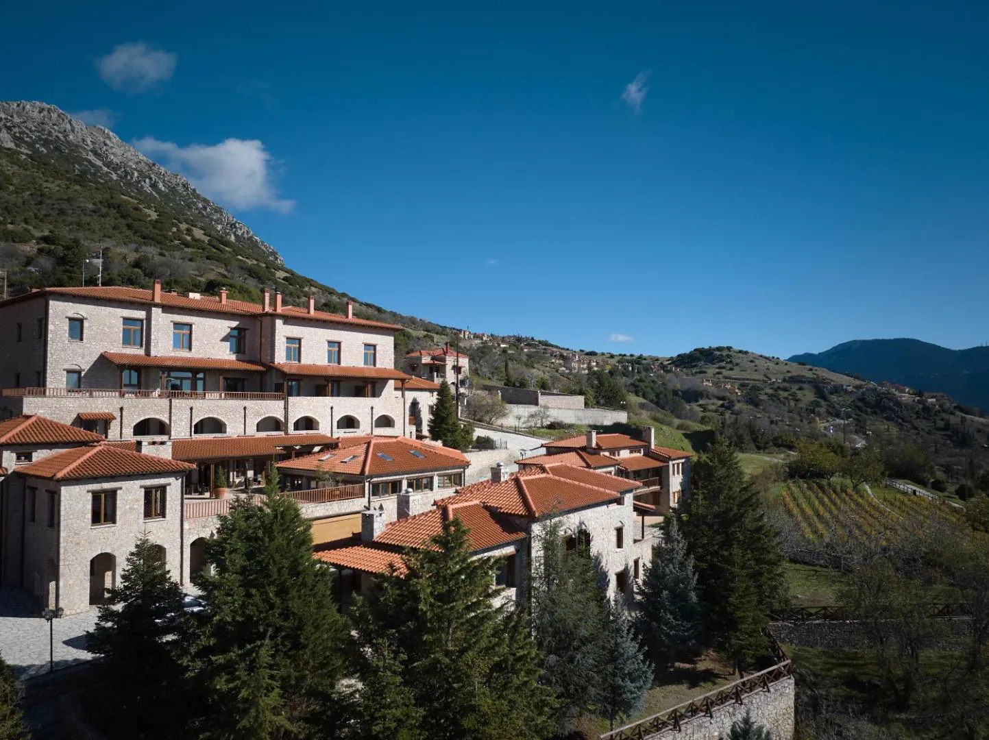 Stone and terracotta-roofed resort buildings on the mountainside