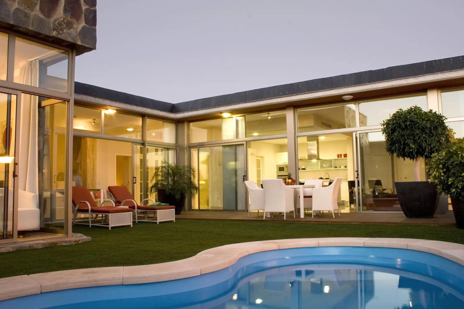 Villa courtyard with a kidney-shaped pool and terrace loungers