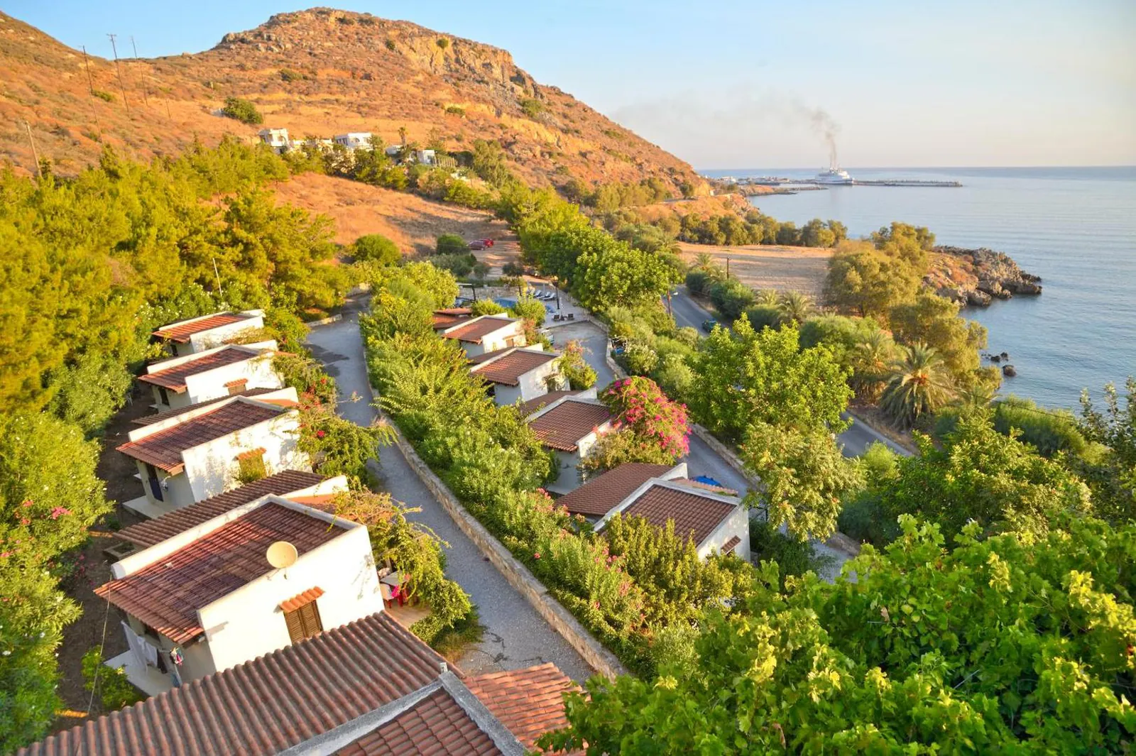 Aerial view of the whitewashed bungalows stepping down through the garden to the sea