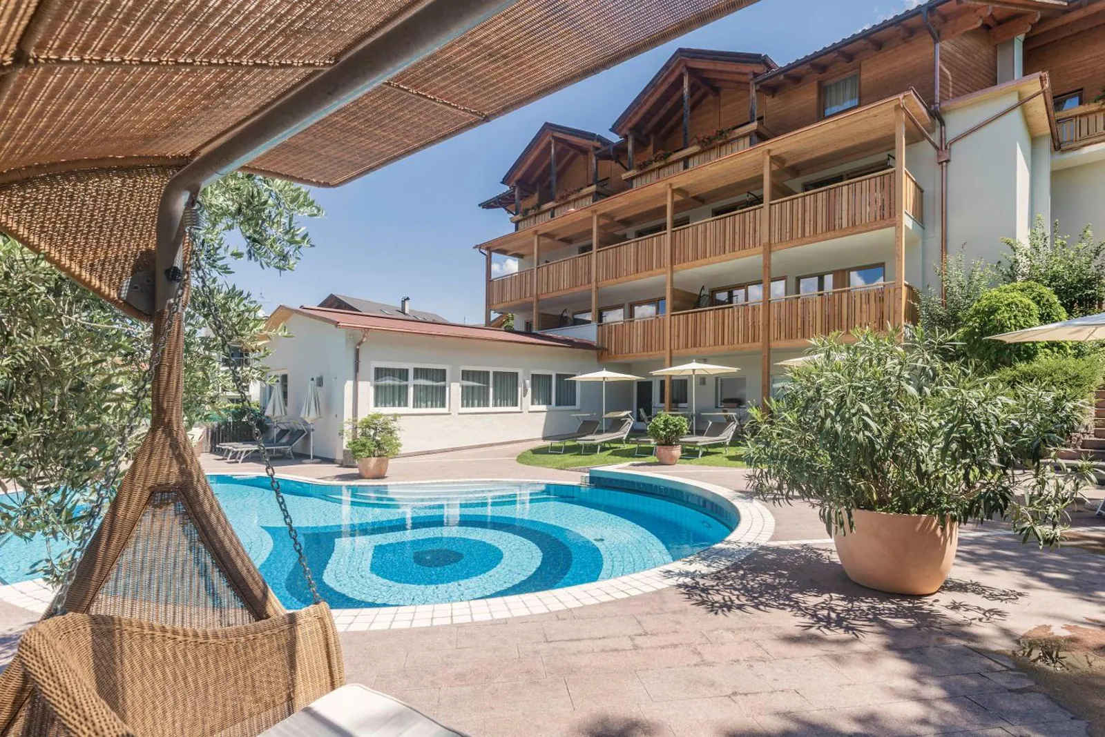 Pool seen from a shaded hanging seat with the hotel behind
